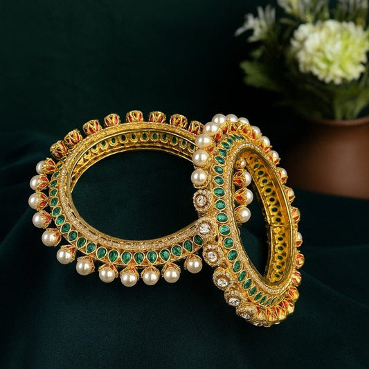 Traditional Gold - Plated Kundan & Pearl Studded Bangles with Green & Red Enamel Work - Auraa Trends - Bangles -  - Auraa Trends - “Traditional gold - plated bangles with green and red enamel, kundan stones, and pearl detailing – set of 2 on velvet background.”