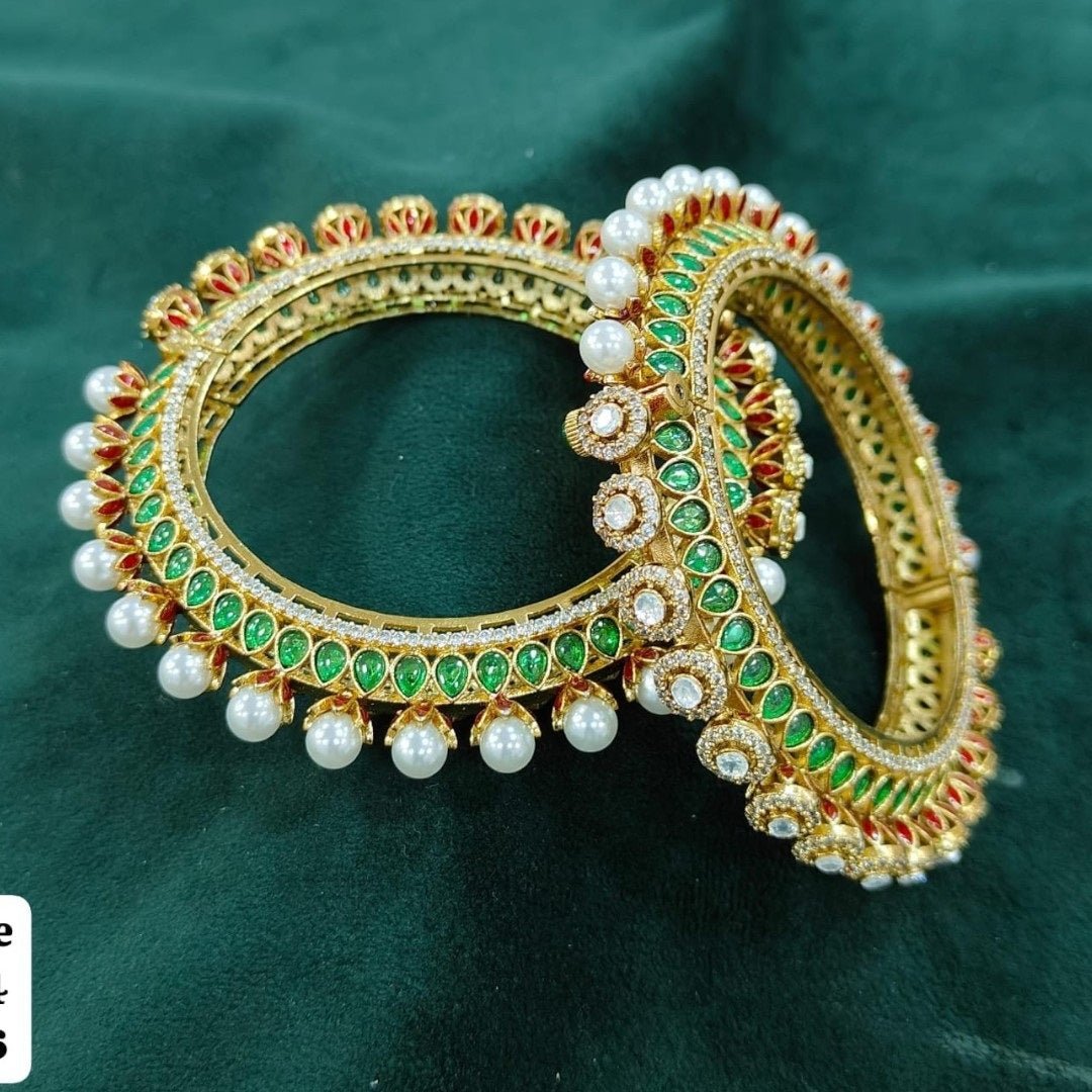 Traditional Gold - Plated Kundan & Pearl Studded Bangles with Green & Red Enamel Work - Auraa Trends - Bangles -  - Auraa Trends - “Traditional gold - plated bangles with green and red enamel, kundan stones, and pearl detailing – set of 2 on velvet background.”