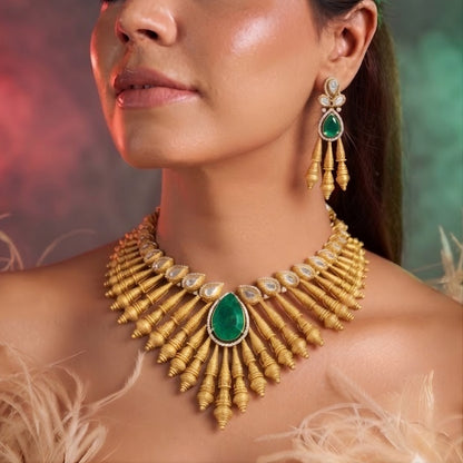 Antique matte gold necklace set with gold cone drops, polki kundan stones, emerald green pear centre stone and matching drop earrings