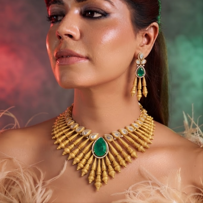 Antique matte gold necklace set with gold cone drops, polki kundan stones, emerald green pear centre stone and matching drop earrings