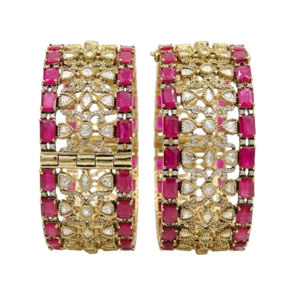 Pair of antique gold-finish wide kada bangles with ruby-pink rectangular stones, polki-style clear stones, and Victorian-style American diamond scrollwork